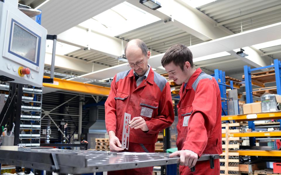 A man showing a young person how to use special tools